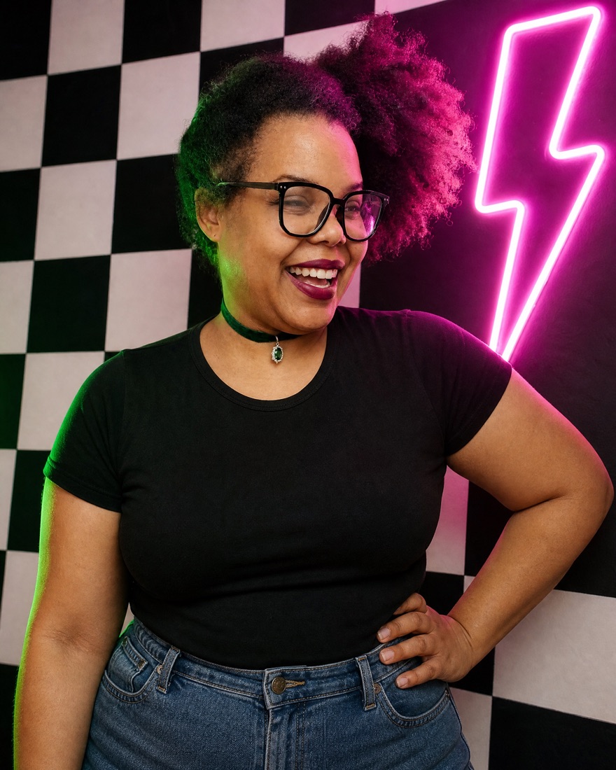 Kiki laughing in front of a checkerboard wall